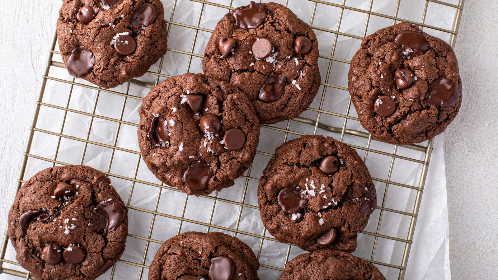 Chocolate cookies with chocolate chips on a cooling rack
